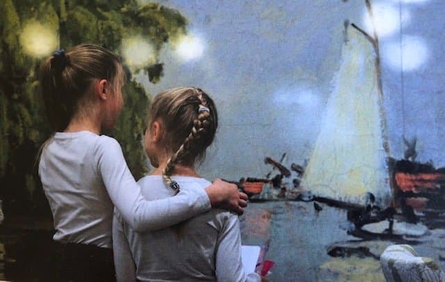 Twee meisjes bij een levensgrote reproductie van een Monetschilderij